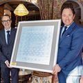 Manuel Küng und Patrik Locatelli von der Schwob AG überreichen Hoteldirektor Heinz E. Hunkeler die 100-jährige Serviette des Kulm Hotel St. Moritz (v. l.).