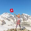 Frau, die eine Schweizer Flagge schwenkt