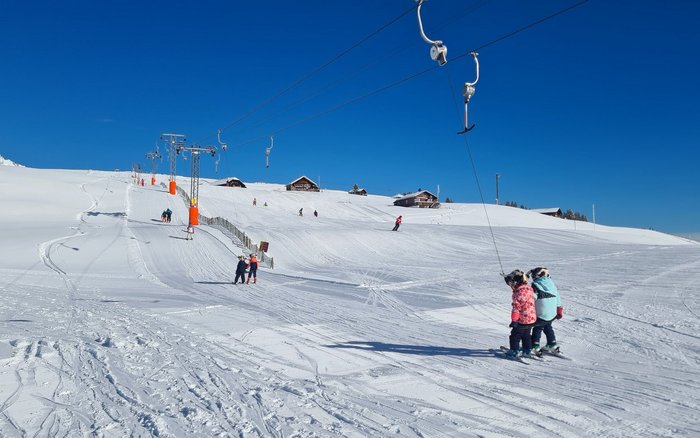 Kinder auf der Skipiste und Lift