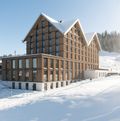 Die 2022 eröffnete Stoos Lodge besticht durch ihre durchgehende Holzfassade. Dank ihr fügt sich das Gebäude ideal ins Ortsbild ein.