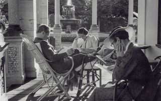 Gäste lesen vor dem Grandhotel Waldhaus.