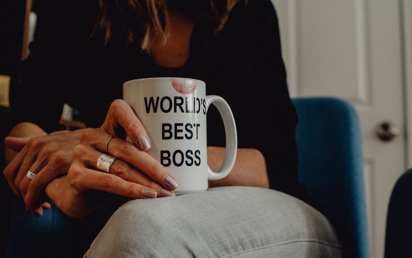 Frau trinkt aus einer Tasse mit der Aufschrift "World's Best Boss"