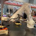 Ein weisser Roboterarm bereitet ein Fondue zu.