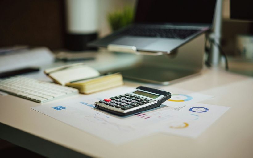 Taschenrechner auf Finanzunterlagen in einem Arbeitsbereich